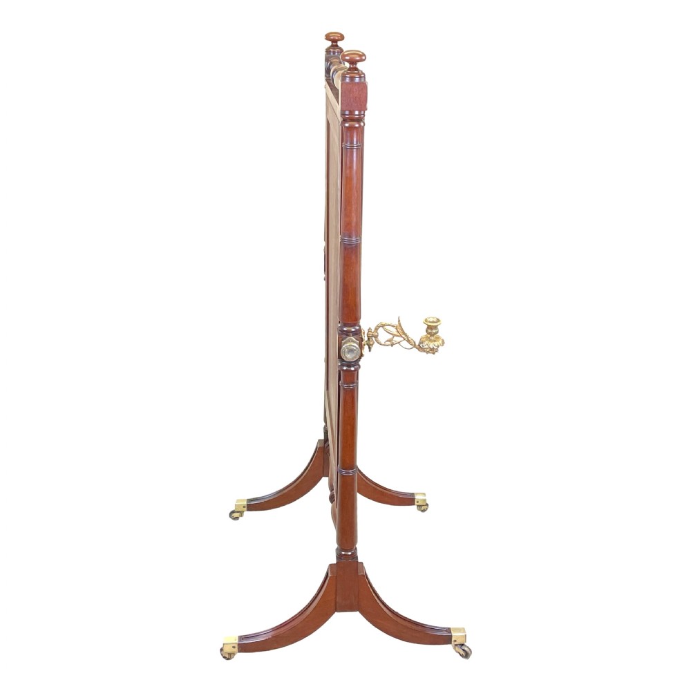A Georgian mahogany freestanding cheval mirror featuring brass candle sconces, turned upright columns, and splayed legs with brass castors. View IX
