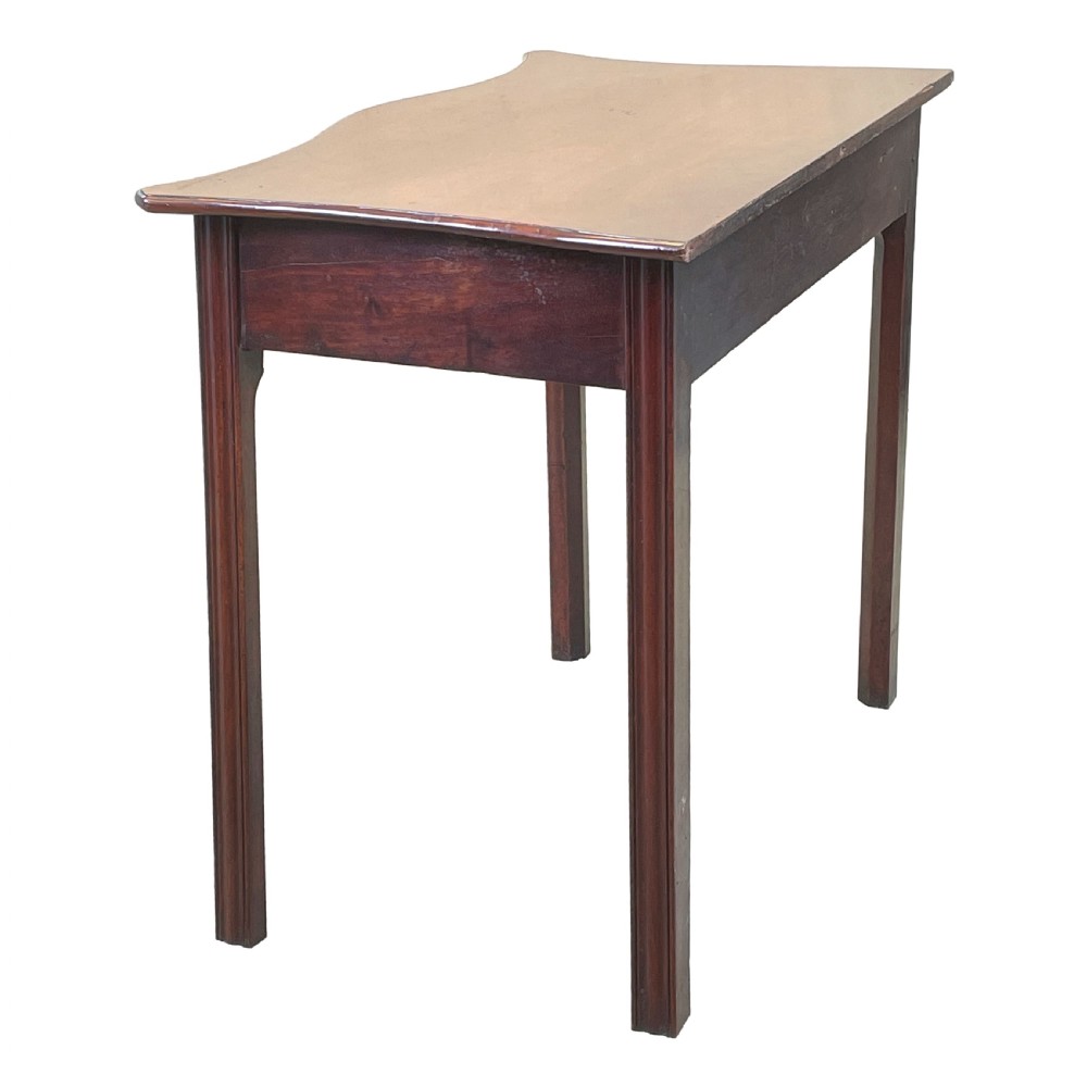 A Georgian mahogany side table featuring a serpentine front, a single drawer with a brass handle, and four straight fluted legs. View III