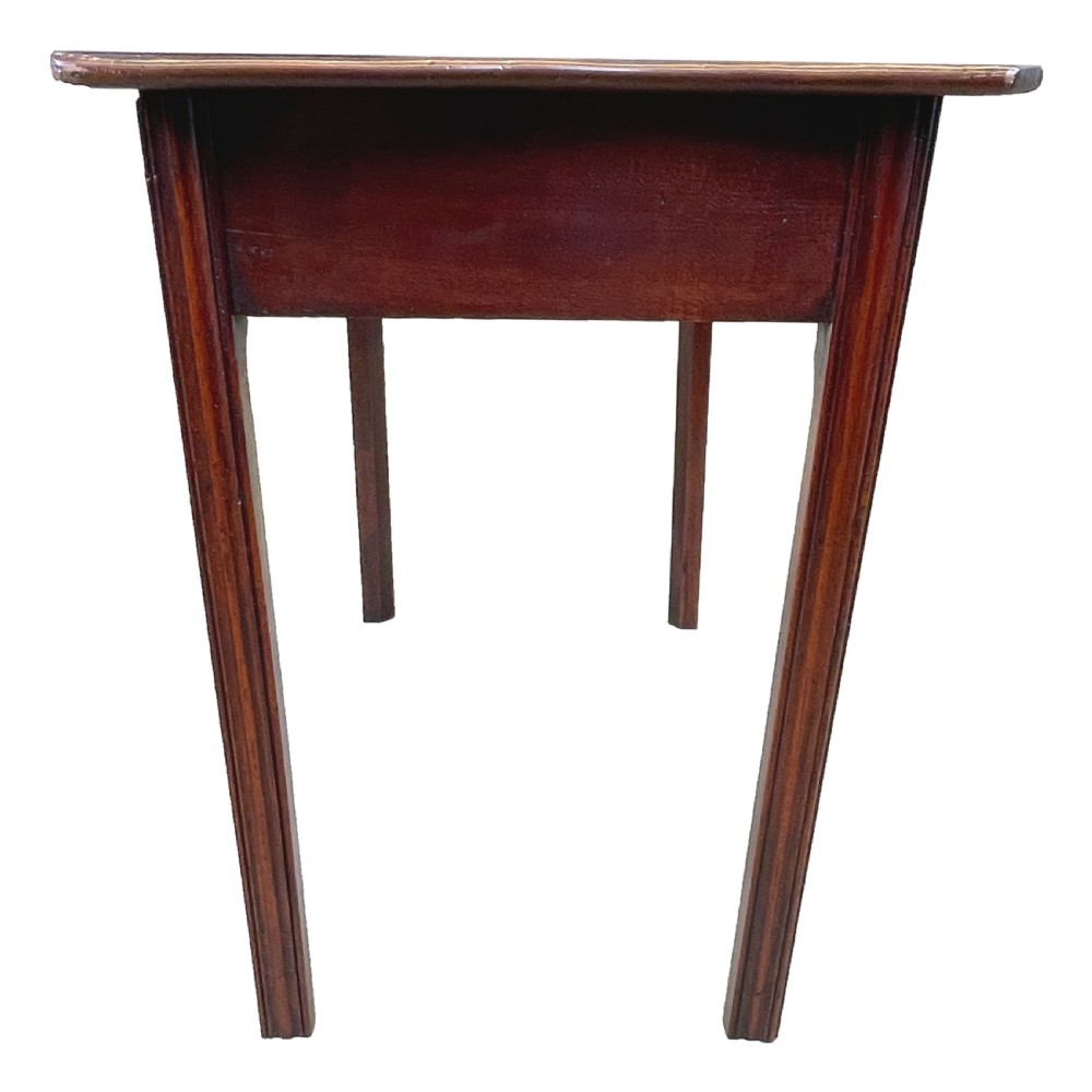 A Georgian mahogany side table featuring a serpentine front, a single drawer with a brass handle, and four straight fluted legs. View VI