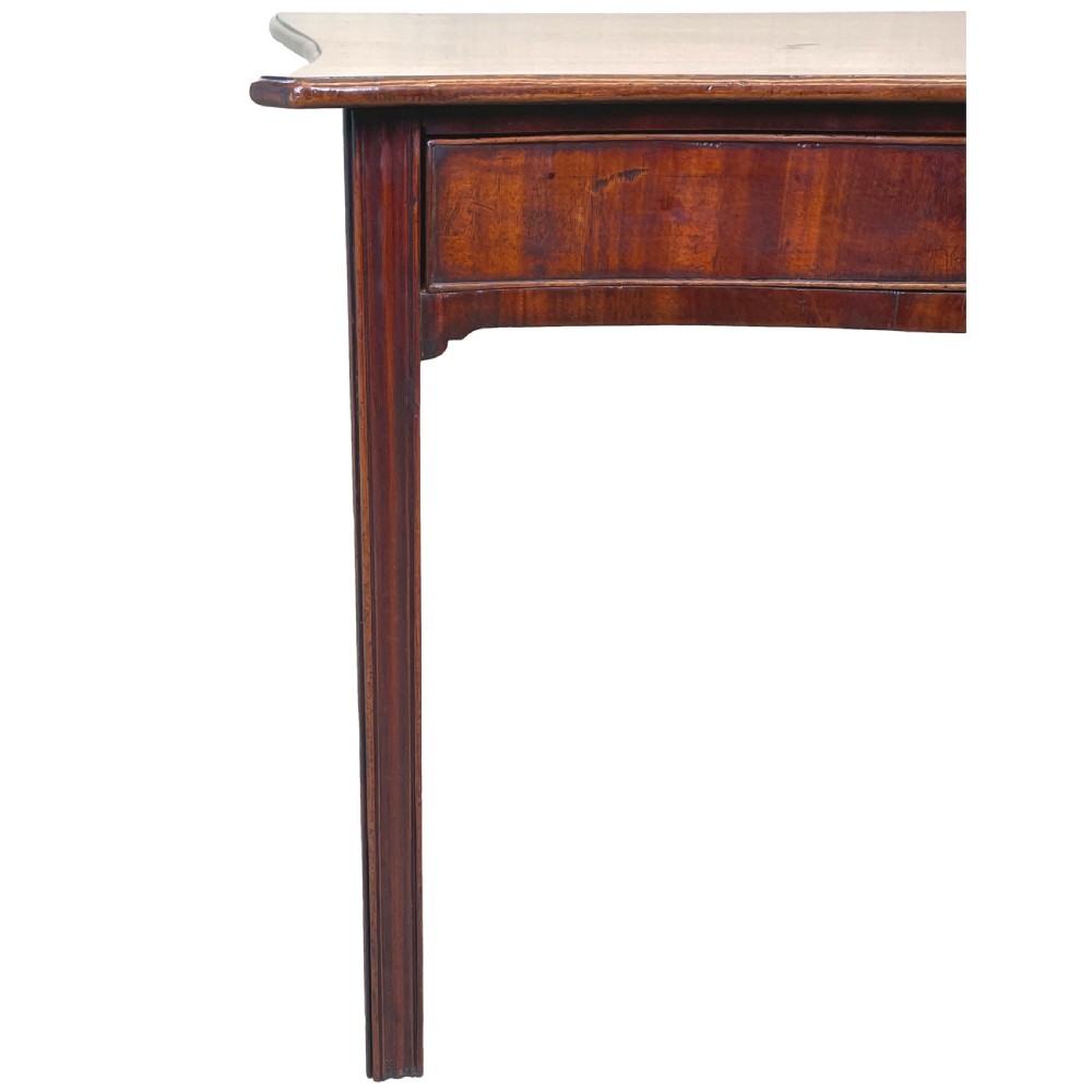 A Georgian mahogany side table featuring a serpentine front, a single drawer with a brass handle, and four straight fluted legs. View VIII
