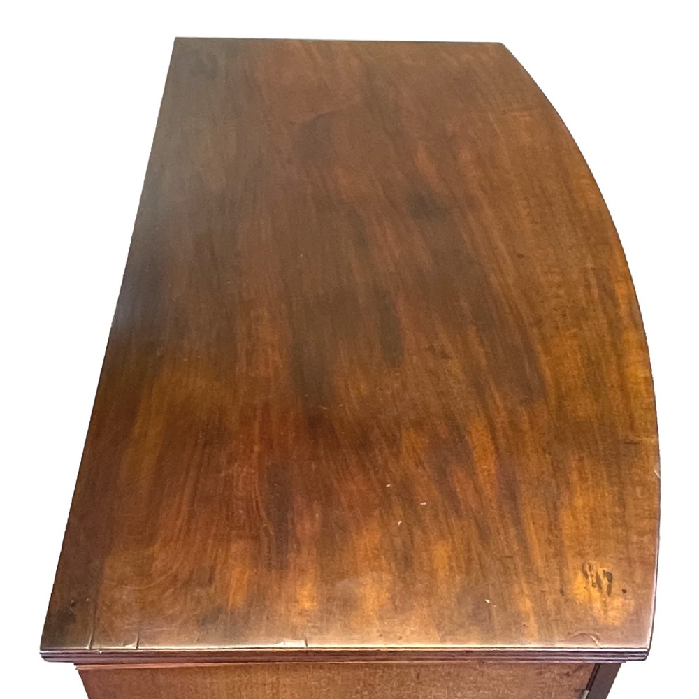 A Georgian bow-front mahogany dwarf cupboard with flame mahogany twin door panels, brass astragal mouldings, and splayed bracket feet. View VII
