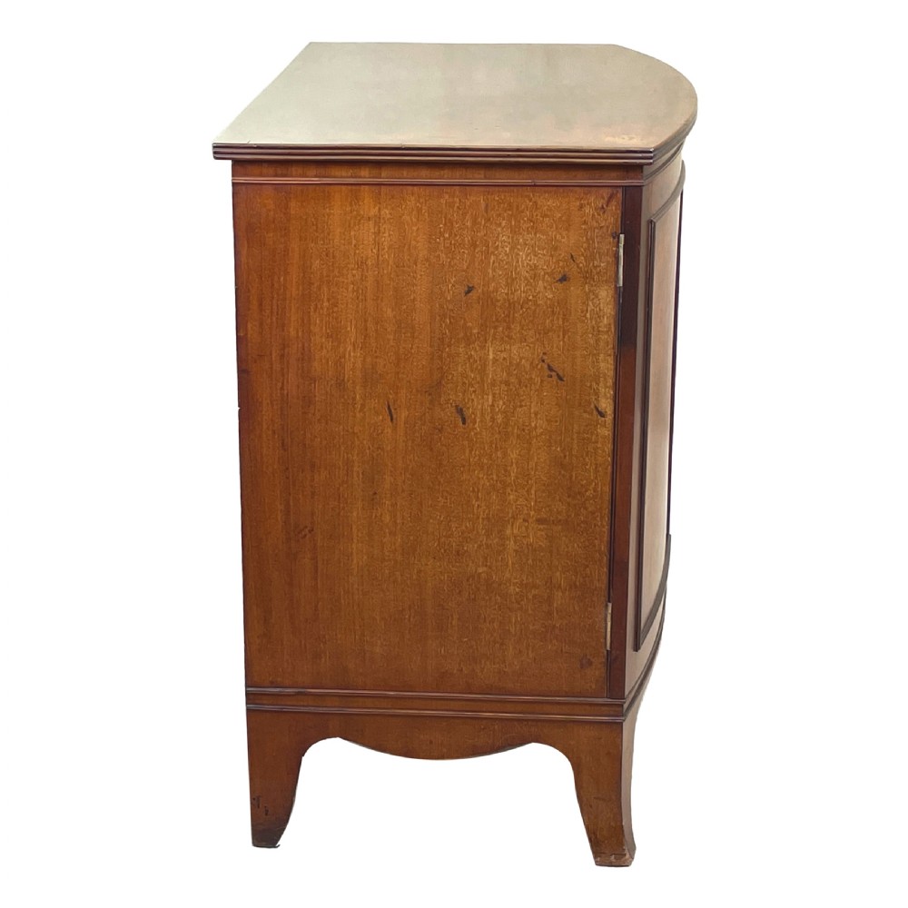 A Georgian bow-front mahogany dwarf cupboard with flame mahogany twin door panels, brass astragal mouldings, and splayed bracket feet. View VIII