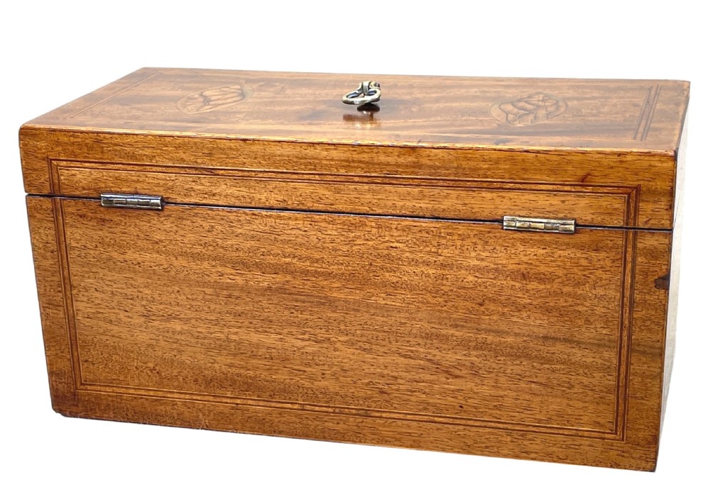 A rectangular Georgian mahogany tea caddy featuring marquetry oval leaf medallions, boxwood stringing, a teardrop escutcheon, and a brass top handle. View VIII