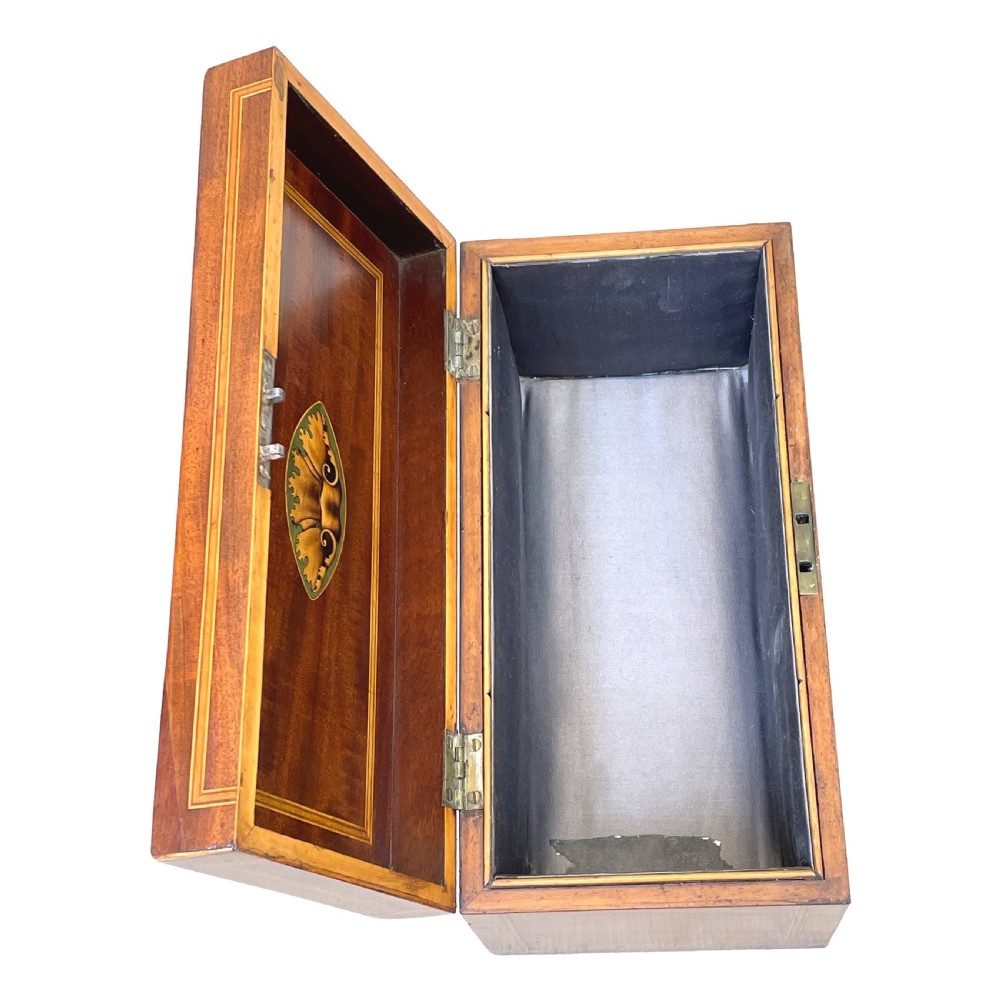 A rectangular Georgian mahogany tea caddy featuring marquetry oval leaf medallions, boxwood stringing, a teardrop escutcheon, and a brass top handle. View IX
