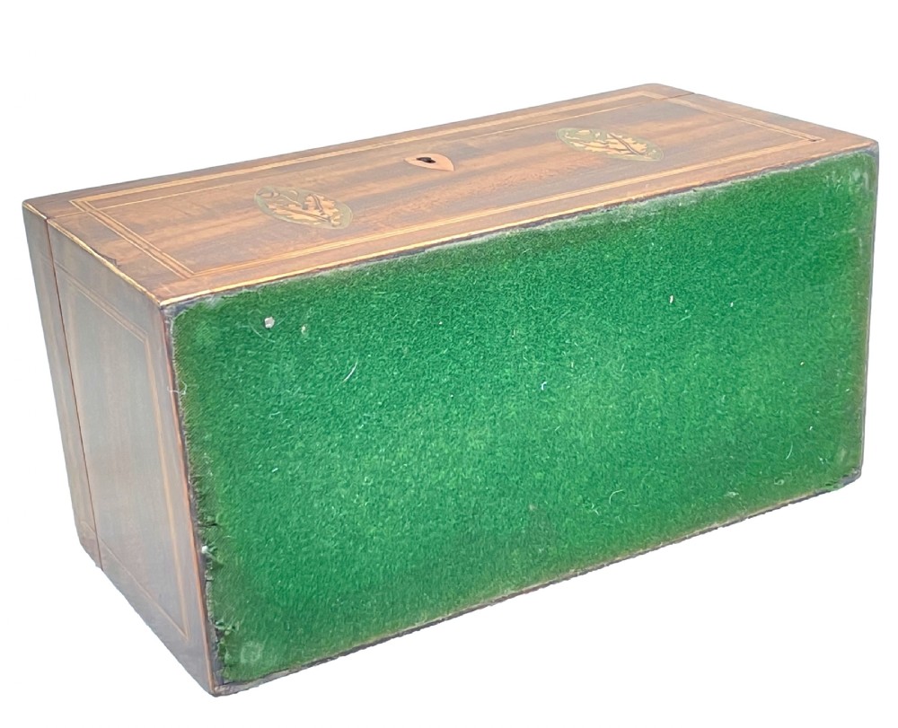 A rectangular Georgian mahogany tea caddy featuring marquetry oval leaf medallions, boxwood stringing, a teardrop escutcheon, and a brass top handle. View X