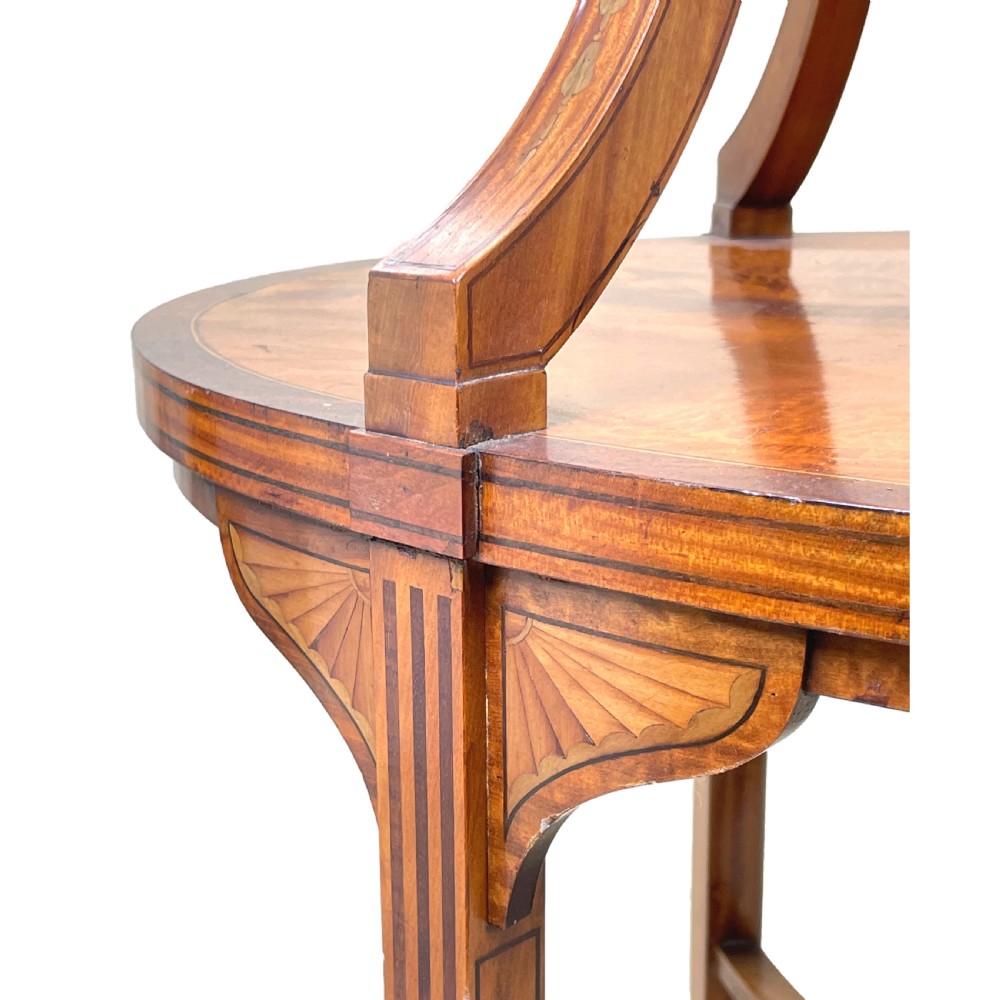 A 19th-century oval satinwood two-tier etagere table featuring geometric stringing inlay, a removable brass-handled upper tray, and outswept legs joined by an X-stretcher. View X