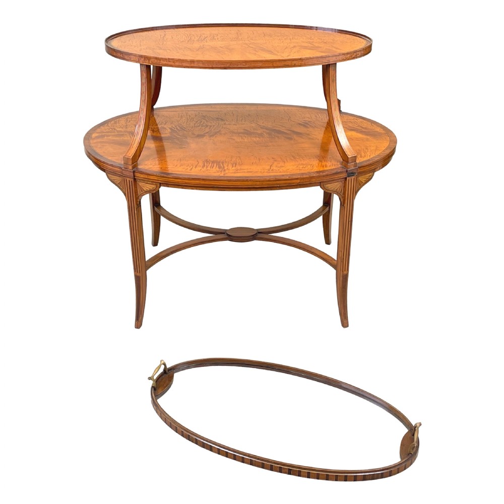 A 19th-century oval satinwood two-tier etagere table featuring geometric stringing inlay, a removable brass-handled upper tray, and outswept legs joined by an X-stretcher. View XII