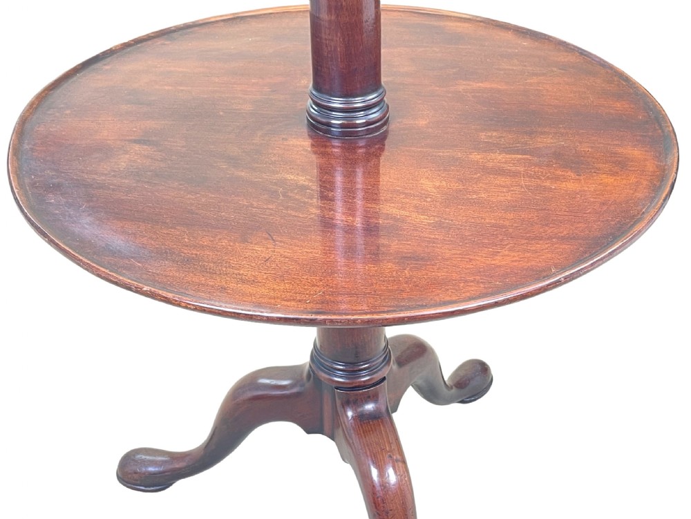 A Georgian mahogany circular dumbwaiter table featuring two graduated tiers raised on a central turned stem and tripod legs. View V