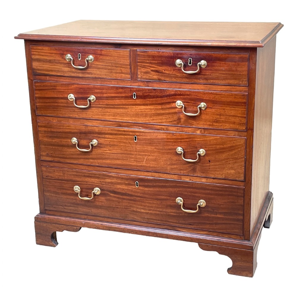 A Georgian mahogany chest of drawers featuring a two-over-three drawer arrangement with brass swan-neck handles and bracket feet.