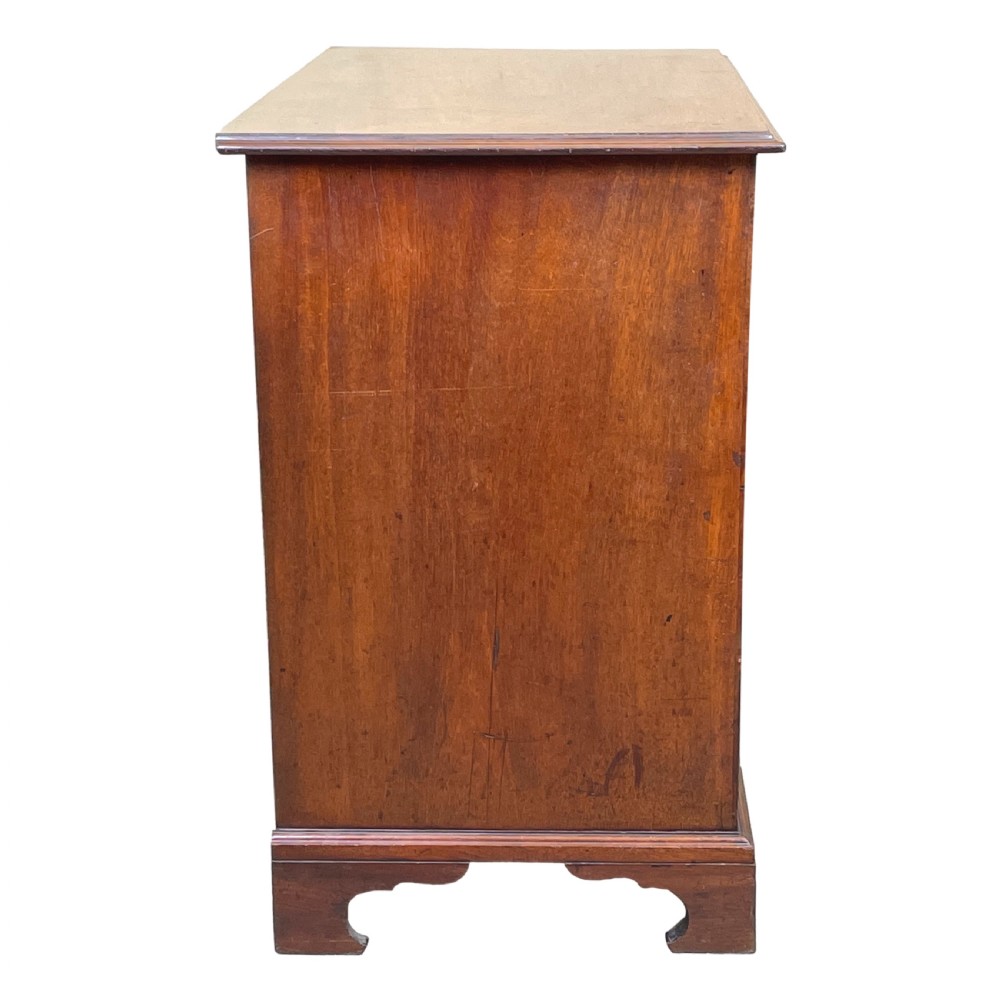 A Georgian mahogany chest of drawers featuring a two-over-three drawer arrangement with brass swan-neck handles and bracket feet. View II
