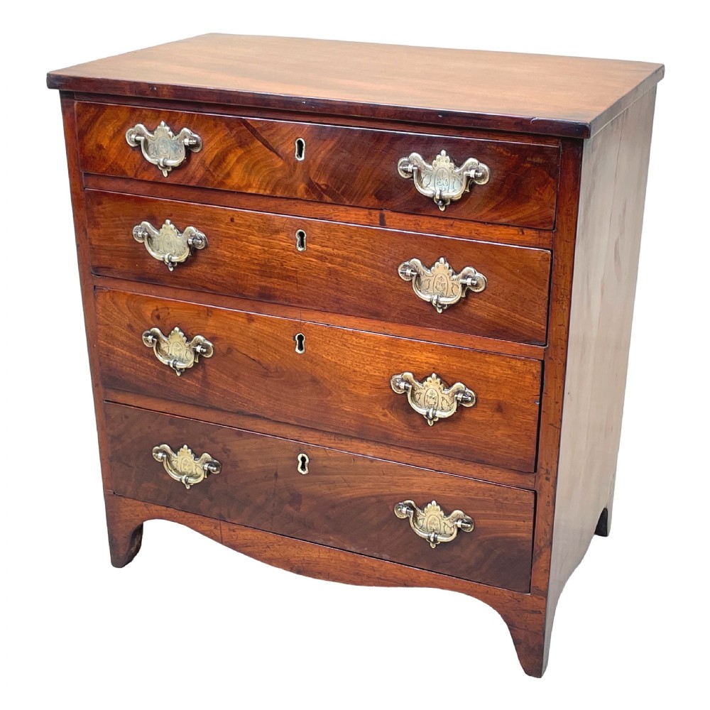 A Georgian mahogany miniature chest of drawers featuring four graduated drawers with ornate brass swan-neck handles and shaped bracket feet.