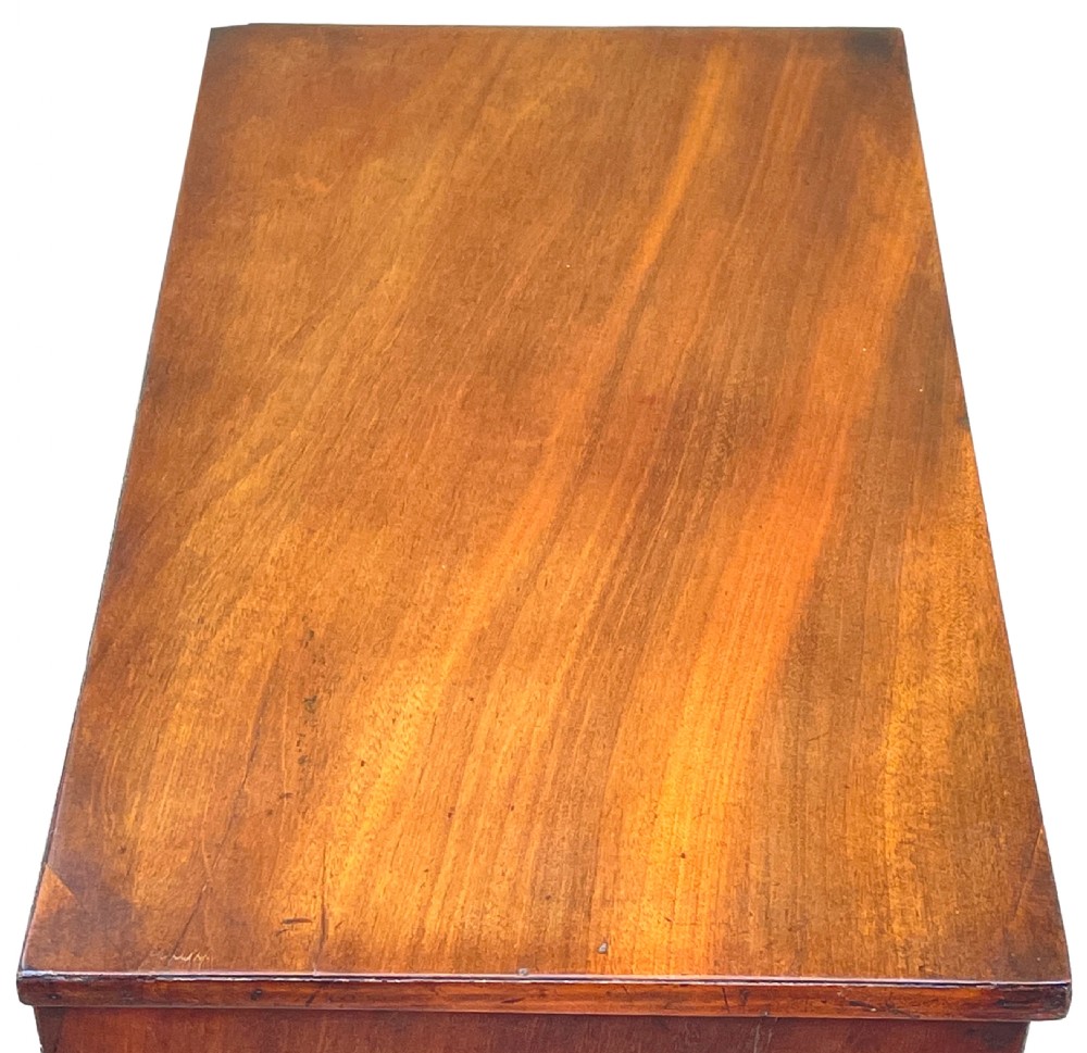 A Georgian mahogany miniature chest of drawers featuring four graduated drawers with ornate brass swan-neck handles and shaped bracket feet. View II