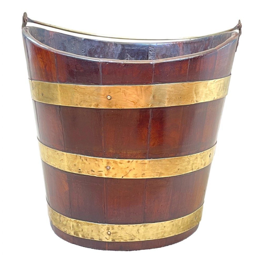 An 18th-century stave-constructed mahogany bucket encircled by three horizontal brass bands with an arched brass swing handle. View IV