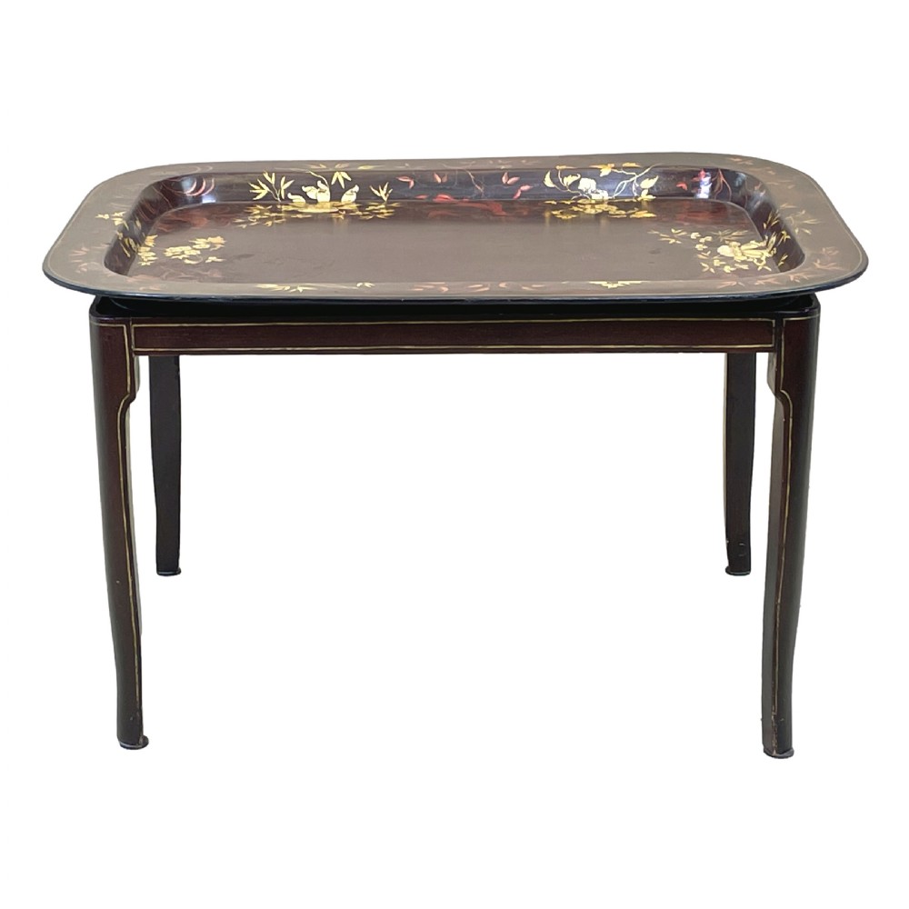 A nineteenth-century dark lacquered papier-mache tray with gold floral decoration resting on a fitted dark wood stand with slender tapered legs. View IV