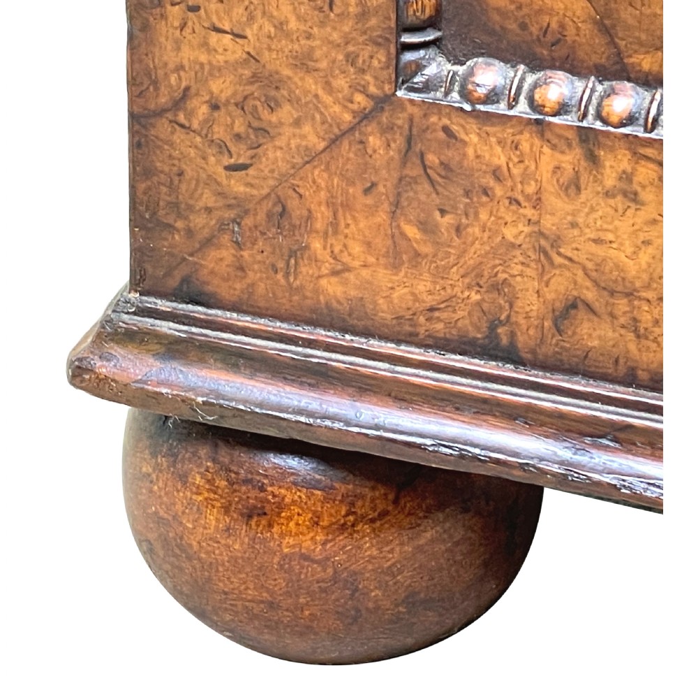 A Regency period burr elm Davenport desk featuring a sloped leather writing surface, a brass gallery railing, side drawers, bead moulding, and turned bun feet. View XV