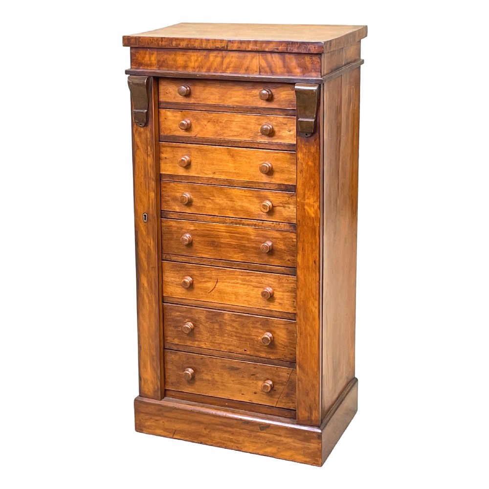 A 19th-century satinbirch childs Wellington chest featuring eight graduating drawers, turned handles, a plinth base, and a side-locking bar.