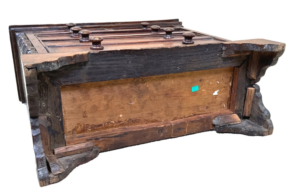 A Georgian oak miniature chest of drawers featuring two short over three long drawers with wooden knobs, turned half-columns, and bracket feet. View IX