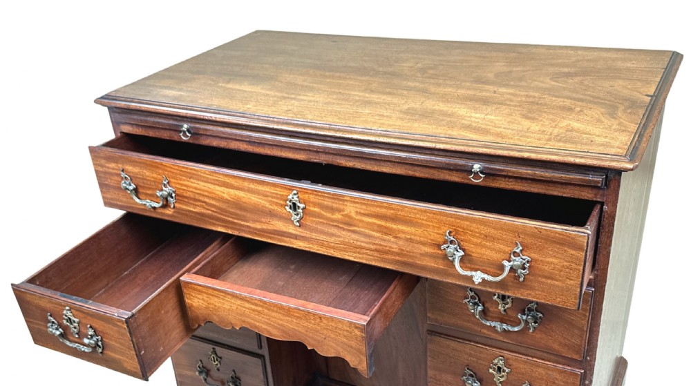 An 18th-century Georgian mahogany kneehole desk featuring brass swan-neck handles, a central recessed cupboard, a pull-out brushing slide, and bracket feet. View IV