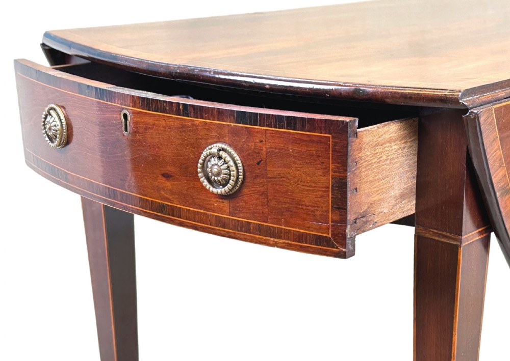 An 18th-century mahogany oval Pembroke table with drop leaves, a single front drawer with brass pull handles, boxwood stringing, square tapered legs, and brass castors. View III