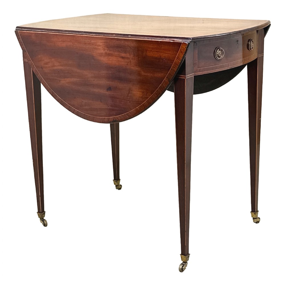 An 18th-century mahogany oval Pembroke table with drop leaves, a single front drawer with brass pull handles, boxwood stringing, square tapered legs, and brass castors. View VIII
