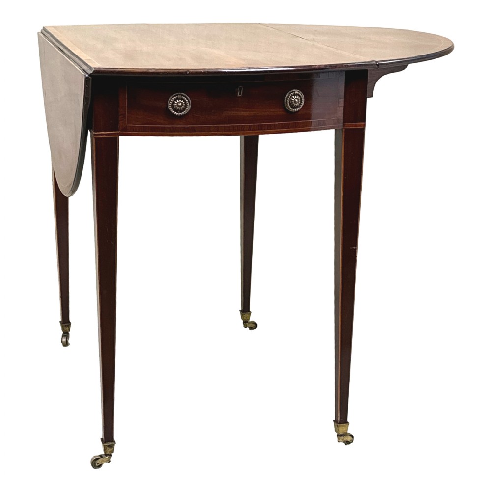 An 18th-century mahogany oval Pembroke table with drop leaves, a single front drawer with brass pull handles, boxwood stringing, square tapered legs, and brass castors. View XII