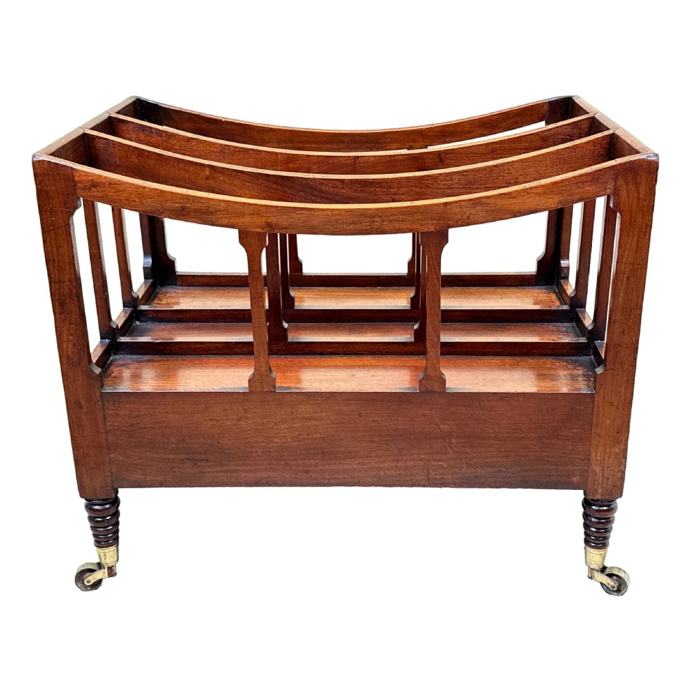 An antique Regency mahogany boat-shaped Canterbury with slatted dividers above a lower drawer on turned legs with brass castors. View IV