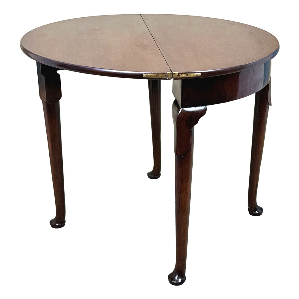 An early Georgian mahogany demilune tea table featuring a fold-over top, a brass escutcheon, and tapered legs ending in pad feet. View III