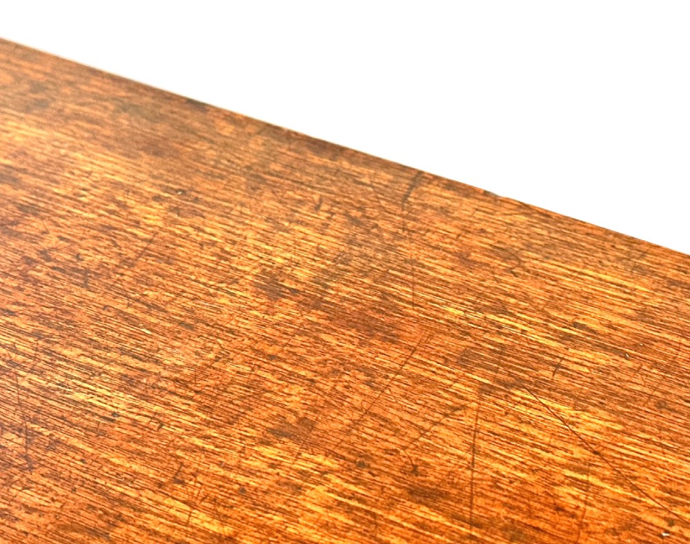An early Georgian mahogany demilune tea table featuring a fold-over top, a brass escutcheon, and tapered legs ending in pad feet. View V