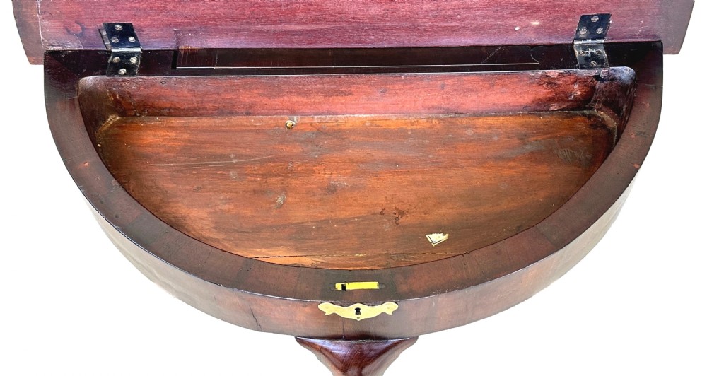 An early Georgian mahogany demilune tea table featuring a fold-over top, a brass escutcheon, and tapered legs ending in pad feet. View XII