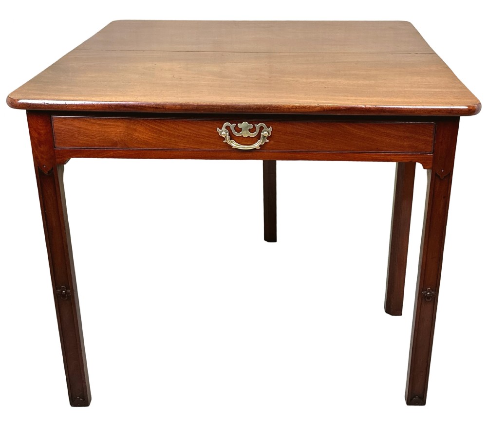 An 18th-century Georgian mahogany drop flap side table featuring a single drawer with a brass handle and carved square legs. View V