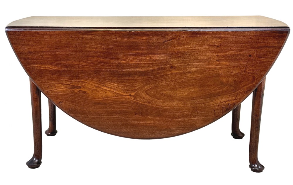 A Georgian dark mahogany drop-leaf dining table with an oval top and tapered legs featuring pad feet. View IX