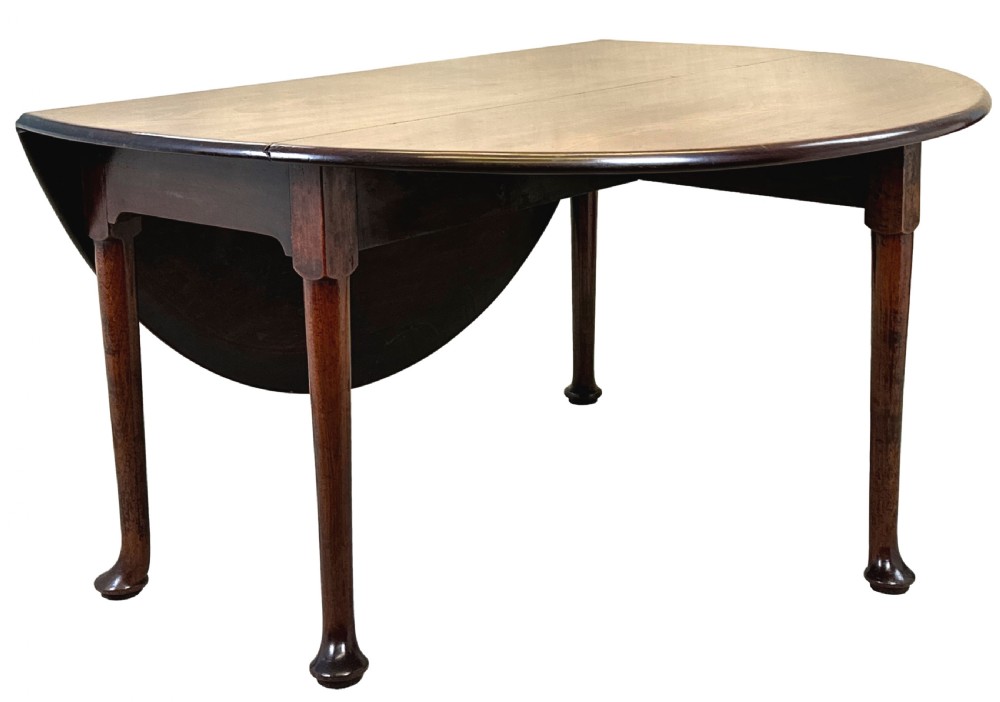 A Georgian dark mahogany drop-leaf dining table with an oval top and tapered legs featuring pad feet. View X