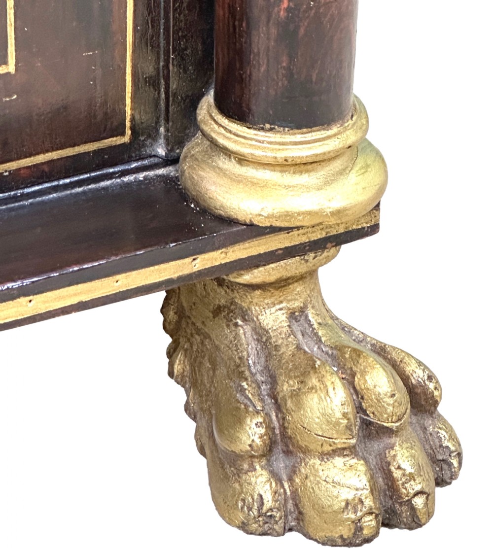 A Regency simulated rosewood side cabinet with gilded floral details, fabric door inserts, side columns, and gilded lion paw feet. View VI