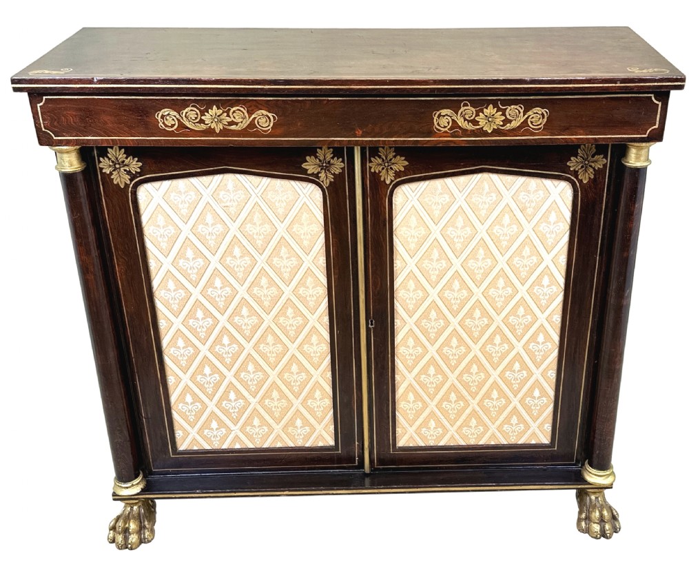 A Regency simulated rosewood side cabinet with gilded floral details, fabric door inserts, side columns, and gilded lion paw feet. View X