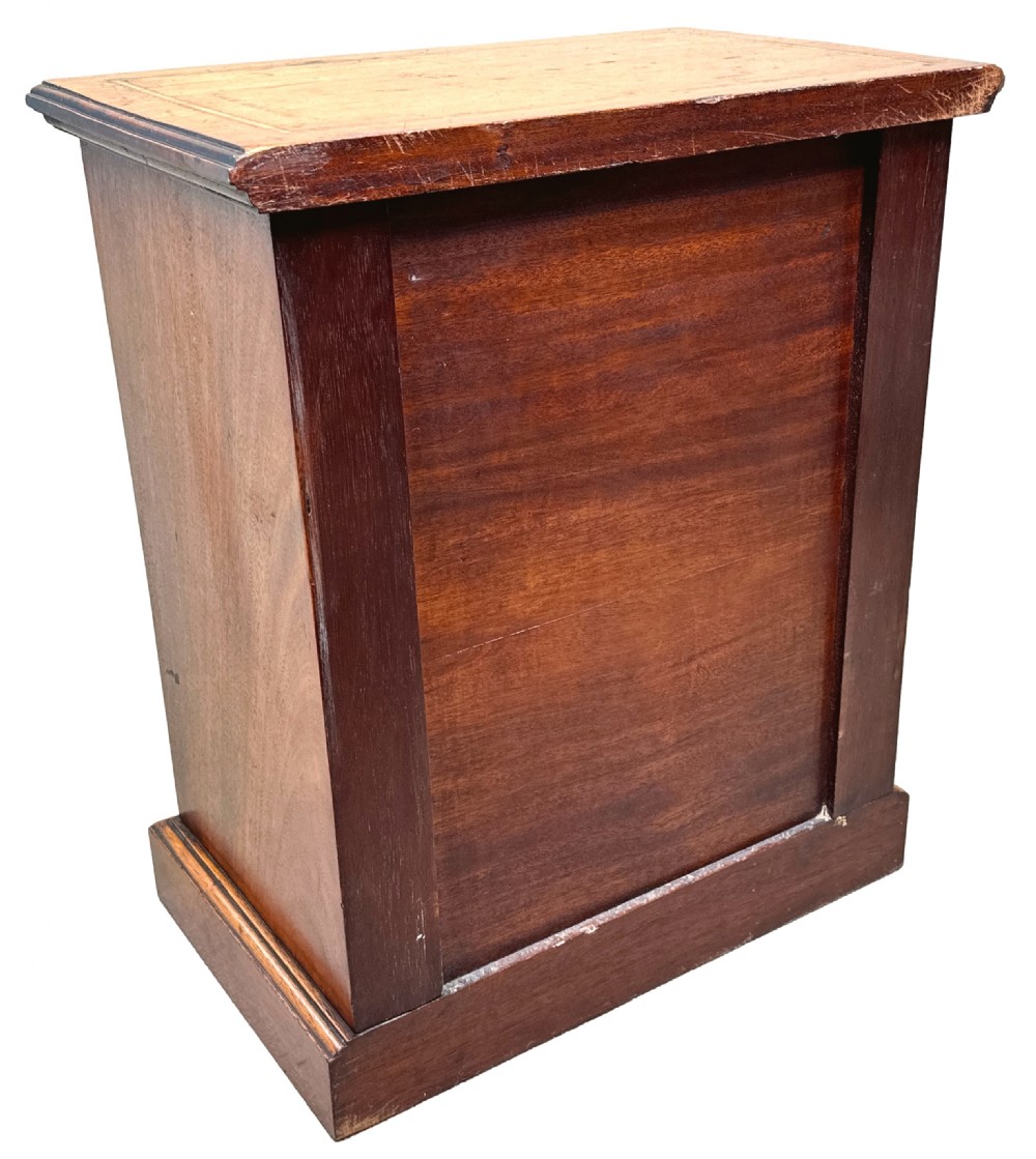 A 19th-century walnut miniature chest of five graduated drawers featuring inlaid crossbanded borders and turned handles on a solid plinth base. View V