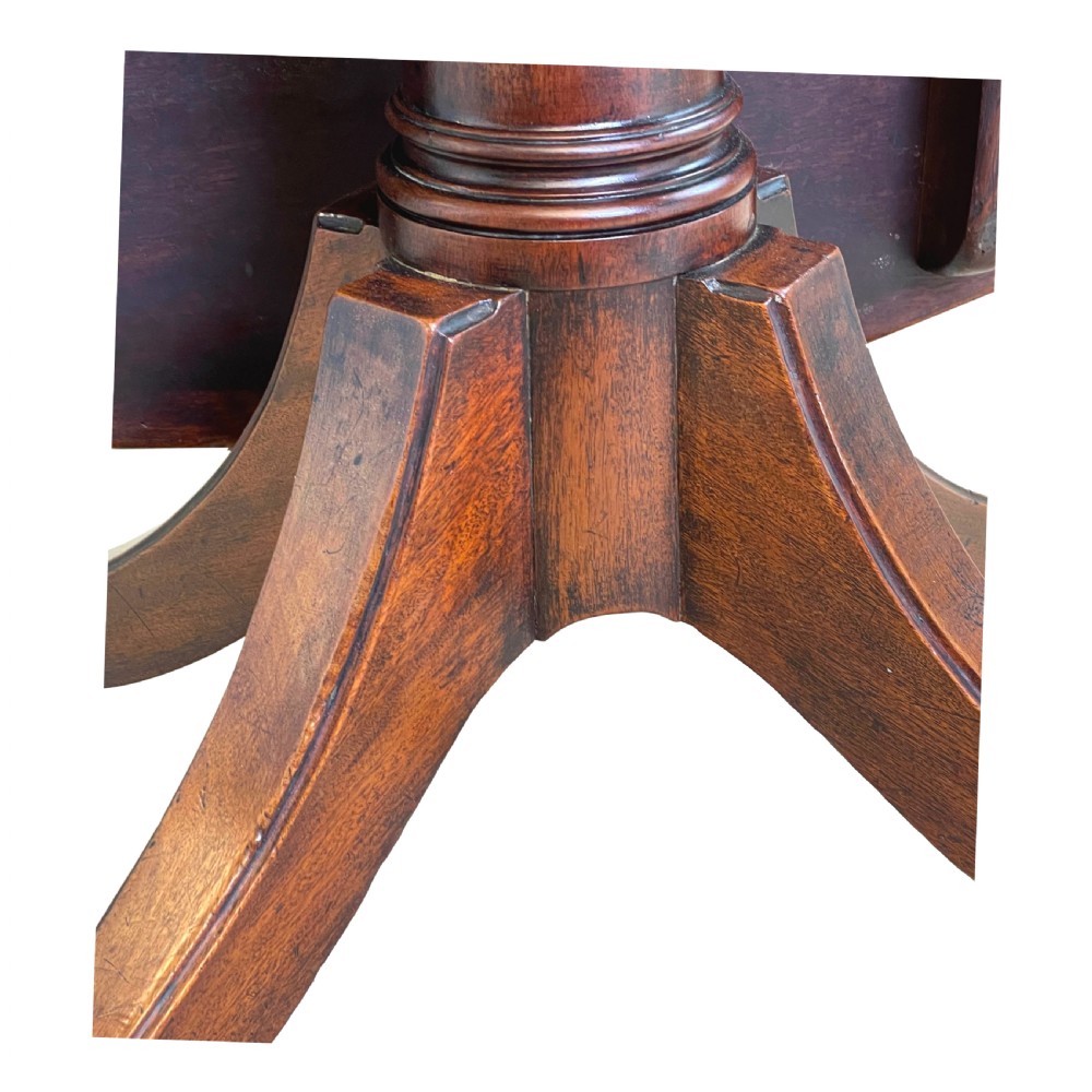 An 18th-century Georgian oval mahogany breakfast table with crossbanded inlay, set on a central turned pedestal with four splayed legs and brass castors. View X