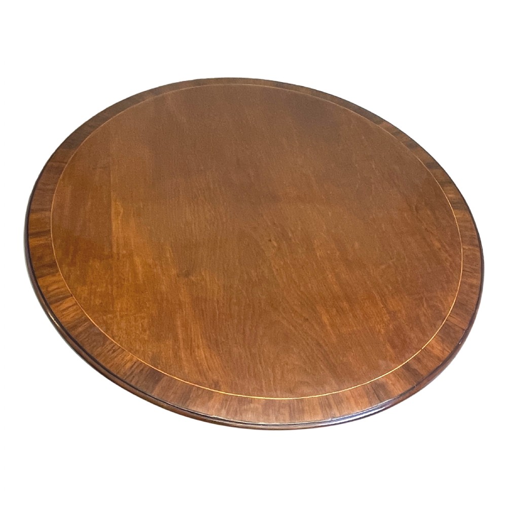 An 18th-century Georgian oval mahogany breakfast table with crossbanded inlay, set on a central turned pedestal with four splayed legs and brass castors. View XII