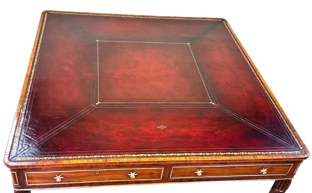 A square Regency mahogany partners writing table with a leather insert top, brass star handles on twin drawers, and fluted legs on castors. View III
