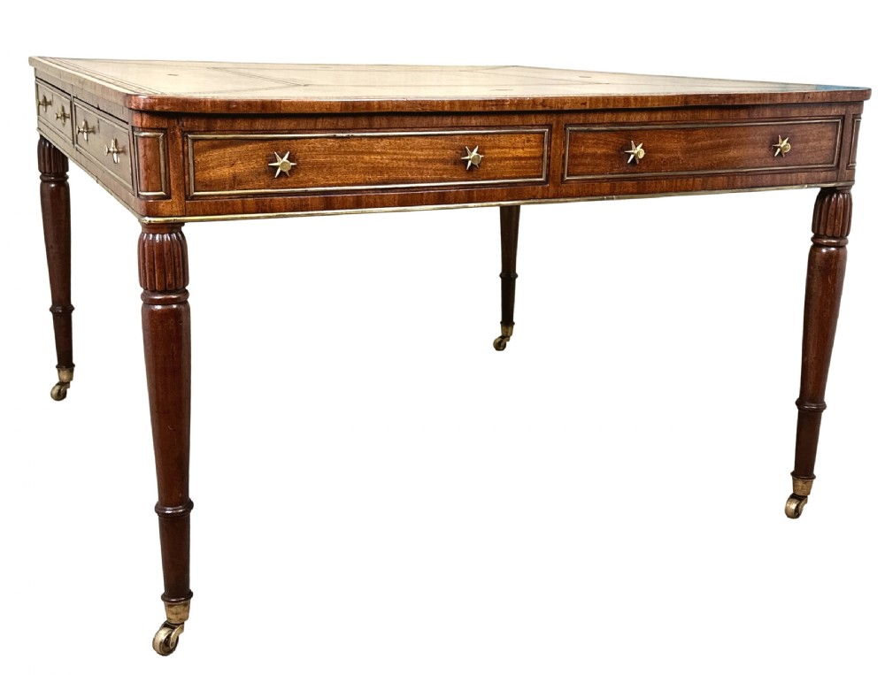 A square Regency mahogany partners writing table with a leather insert top, brass star handles on twin drawers, and fluted legs on castors. View VIII