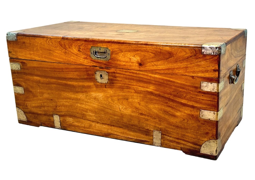 A 19th-century rectangular camphor wood campaign trunk featuring brass corner brackets, flush side handles, and a brass keyhole escutcheon.