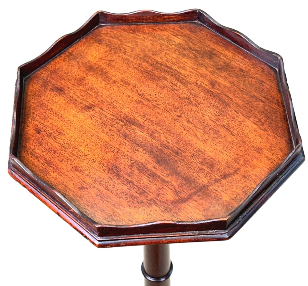 A tall George III mahogany torchere candle stand featuring a scalloped gallery top, turned column shaft, and splayed tripod legs. View II