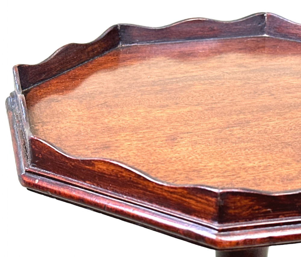 A tall George III mahogany torchere candle stand featuring a scalloped gallery top, turned column shaft, and splayed tripod legs. View III