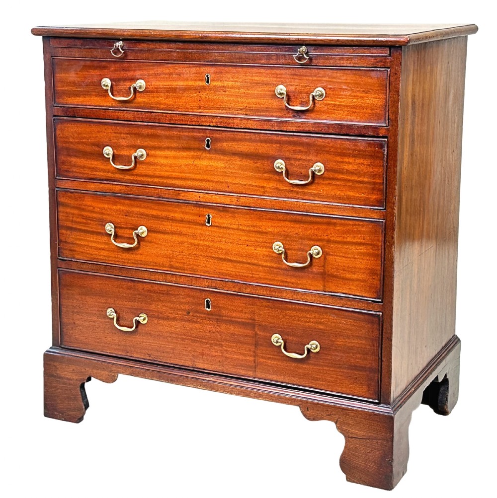 A Georgian mahogany chest of drawers featuring four graduated drawers, a pull-out brushing slide, brass swan-neck handles, and bracket feet.