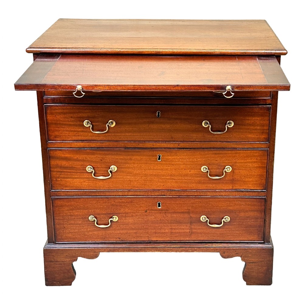 A Georgian mahogany chest of drawers featuring four graduated drawers, a pull-out brushing slide, brass swan-neck handles, and bracket feet. View VI
