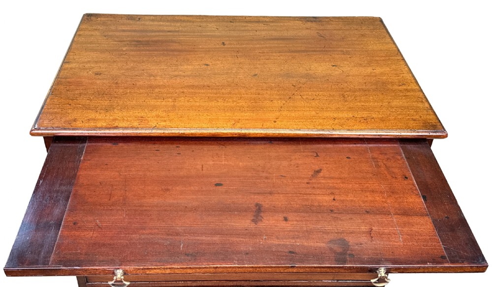 A Georgian mahogany chest of drawers featuring four graduated drawers, a pull-out brushing slide, brass swan-neck handles, and bracket feet. View VII