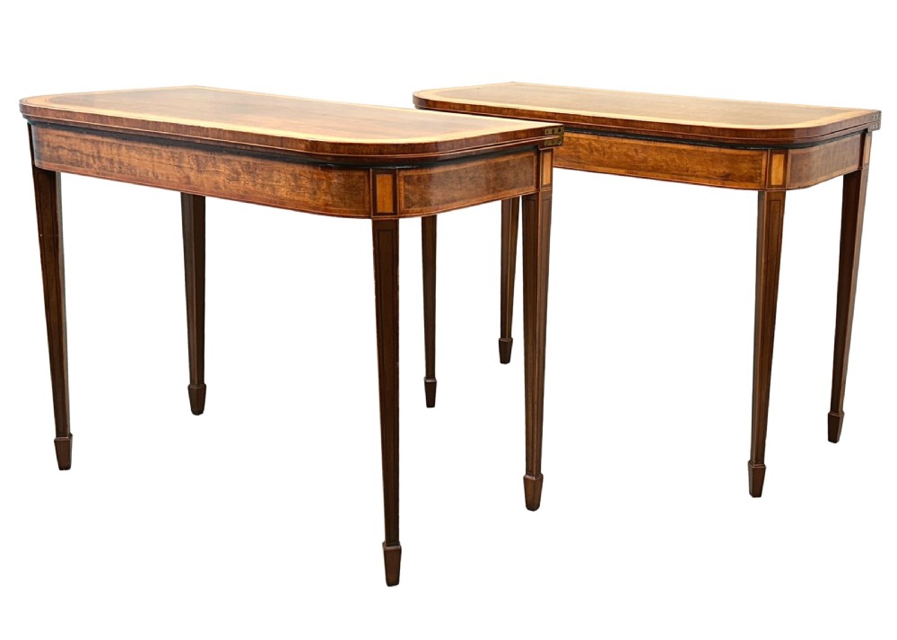 A pair of late Georgian mahogany fold-over card tables featuring satinwood crossbanding and square tapered legs.