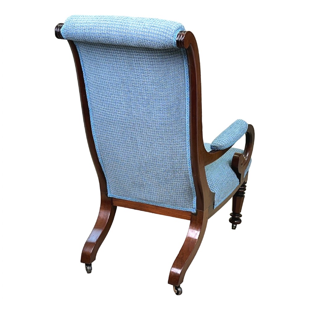 A William IV mahogany library armchair featuring light blue textured upholstery, scrolled armrests, turned front legs, and brass castors. View VIII