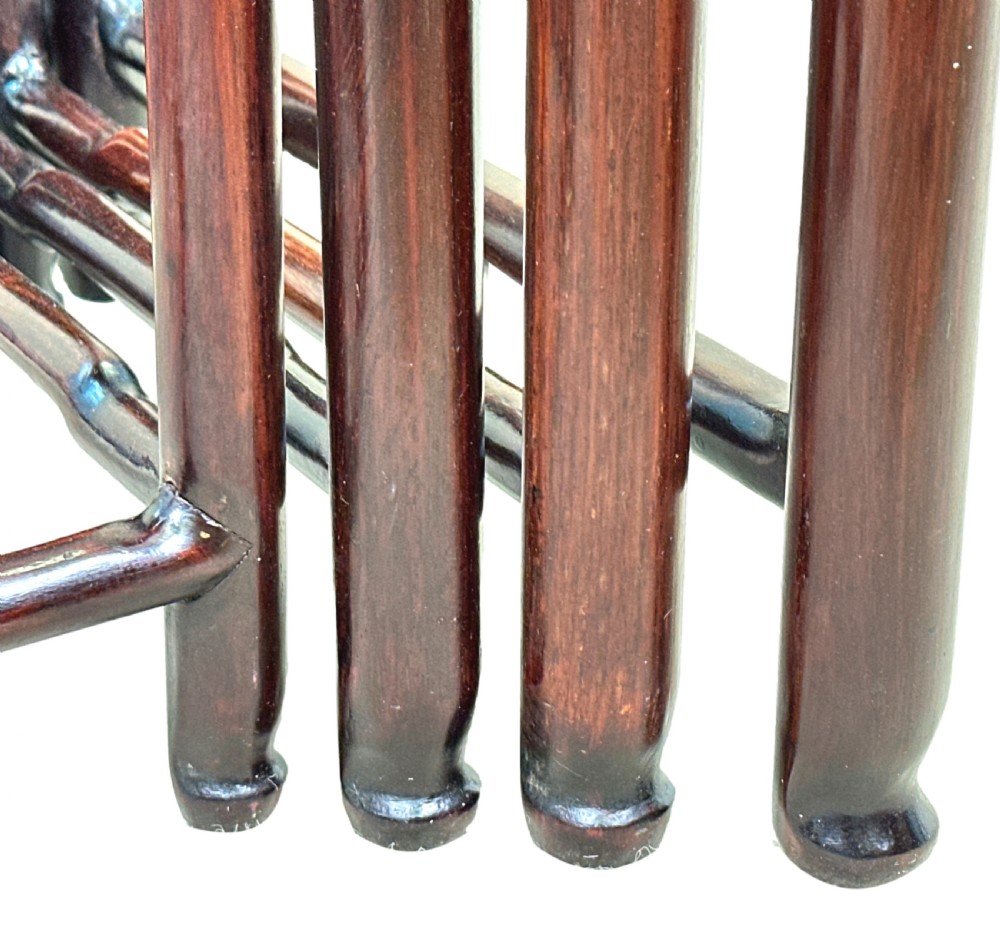 A nest of four graduated dark reddish-brown Oriental hardwood occasional tables featuring pierced carved aprons and slim straight legs. View VI