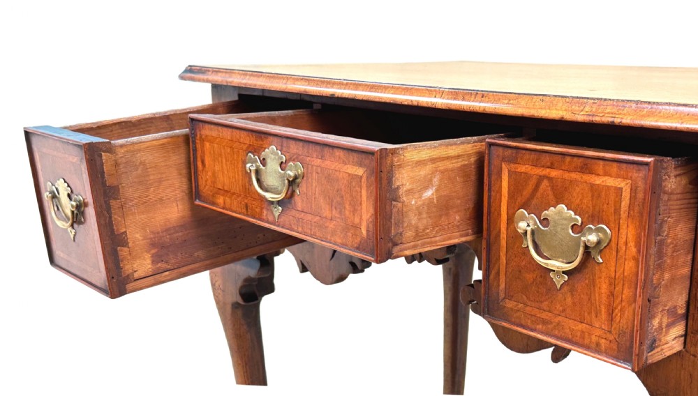 An 18th-century Georgian walnut lowboy table with three drawers, brass drop handles, a carved apron, and cabriole legs. View VI