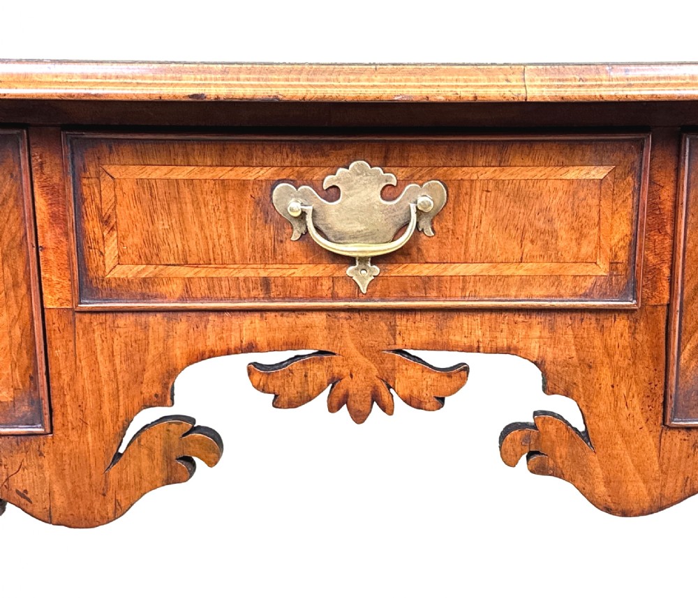 An 18th-century Georgian walnut lowboy table with three drawers, brass drop handles, a carved apron, and cabriole legs. View XIV
